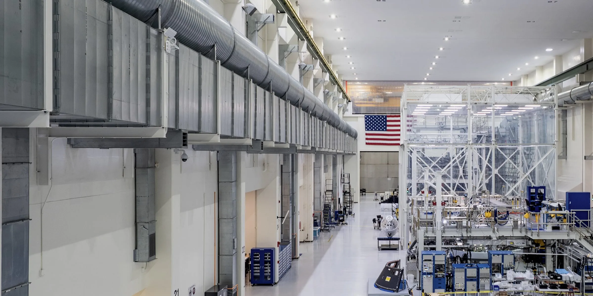 Wide view of an aerospace assembly hall lined with work stations.